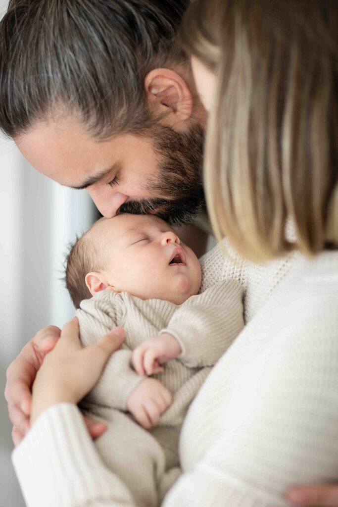 Mom and dad holding newborn. Newborn photography in Kitchener-Waterloo.