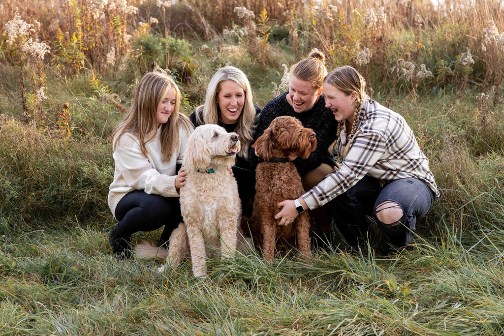 family with dogs in fall clothing for fall photoshoot