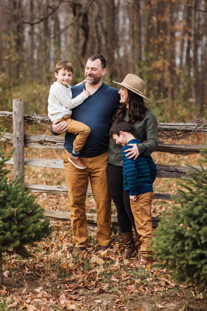 family wearing fall colours standing beside fence during the Fall

