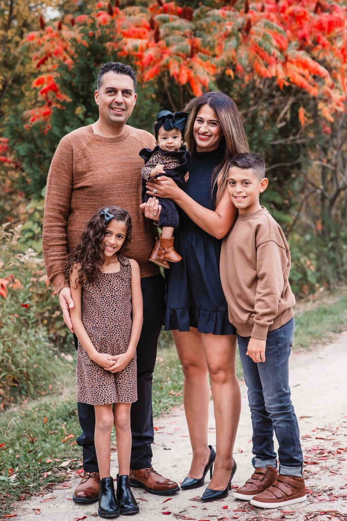 family standing in front of fall foilage