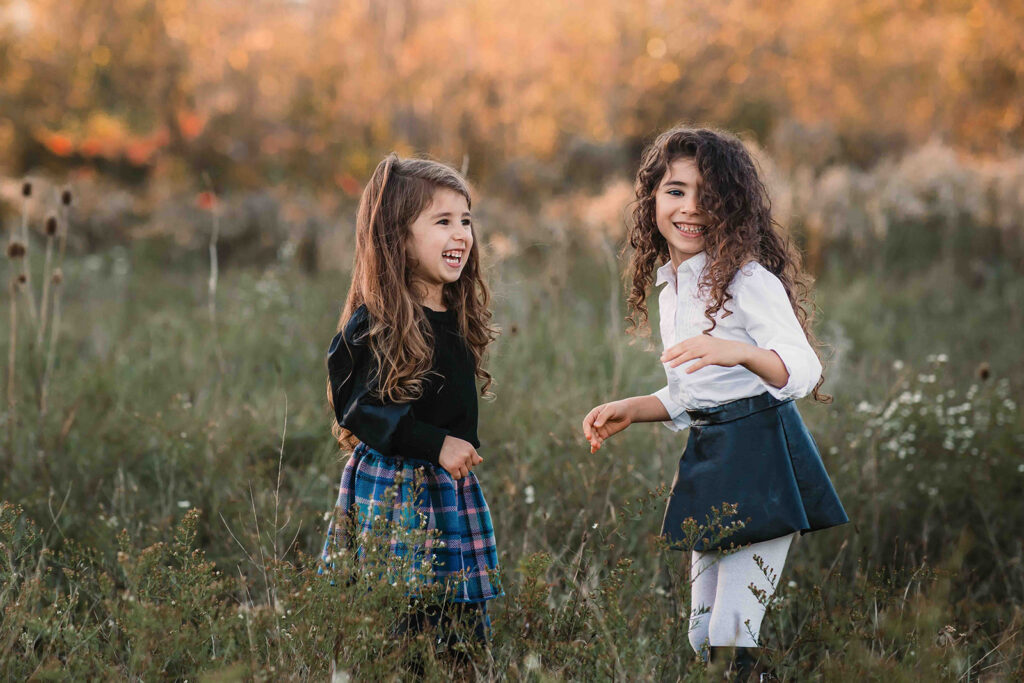 girls laughing in a field of fall colours
