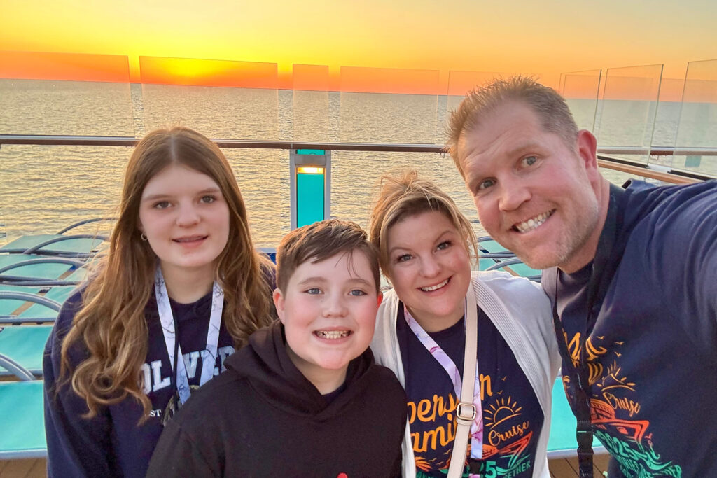 Kendra of Portrait by Kendra with her family. Family selfie at sunset during a March Break cruise, capturing real-life moments outside the photography studio.