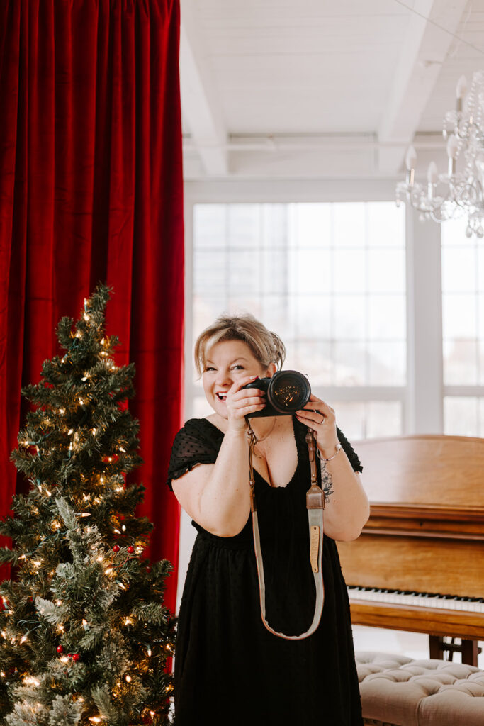 Behind-the-scenes portrait of Kitchener-Waterloo photographer Kendra holding her camera during a branding photoshoot. Portraits by Kendra.