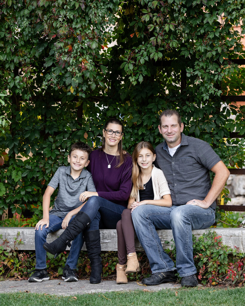 Family portrait of parents and two children captured during a relaxed outdoor session with Kitchener-Waterloo family photographer Portraits by Kendra.