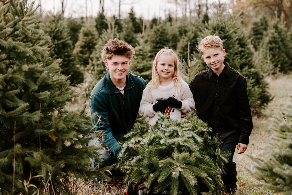 Holiday mini photo session at Chickadee Tree Farm featuring warm family moments among the Christmas trees — captured by Portraits by Kendra, Kitchener-Waterloo family photographer.