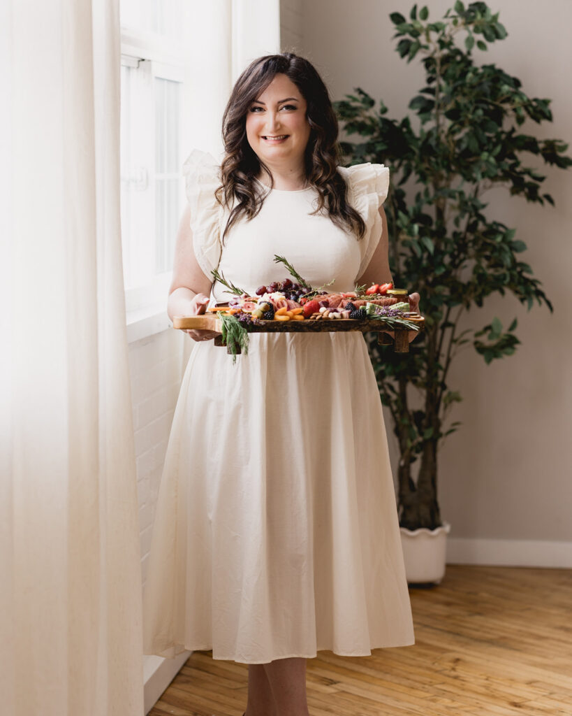 Personal branding portrait of a woman holding a charcuterie board during a lifestyle photography session in Waterloo Region. Marycuterie photographed by Portraits by Kendra.