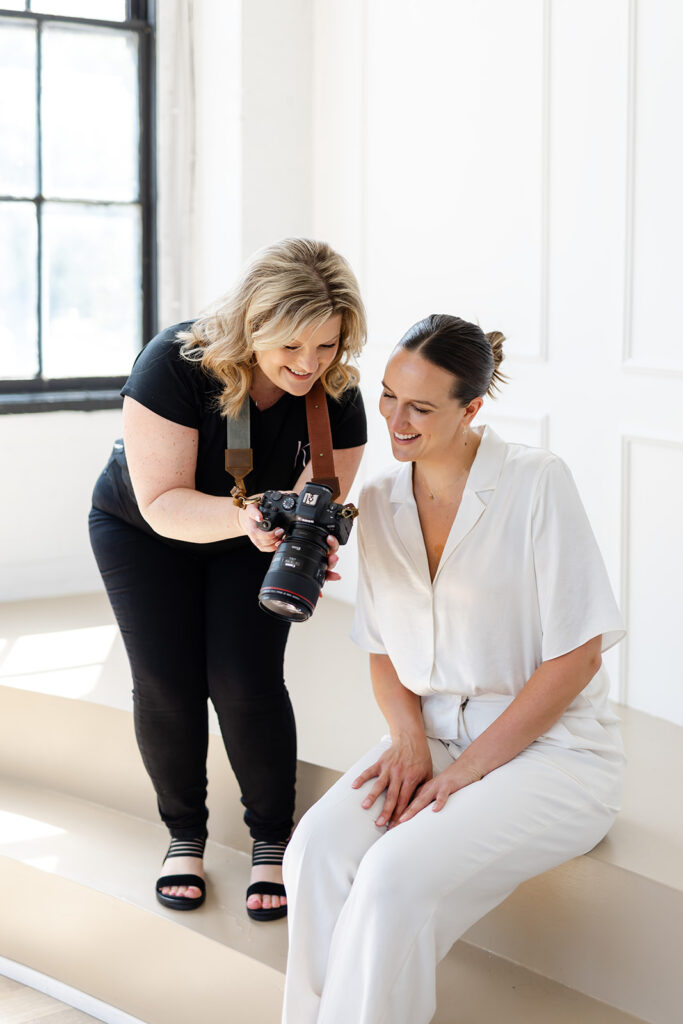 Behind-the-scenes photo of Kendra photographing a client in a casual branding session setup
