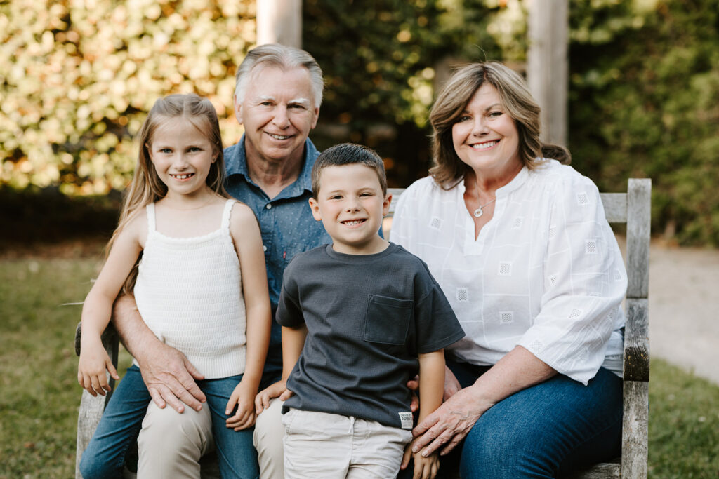 Outdoor photo of grandparents with grandchildren taken at the Guelph Arboretum by Kitchener-Waterloo photographer, PortraitsByKendra