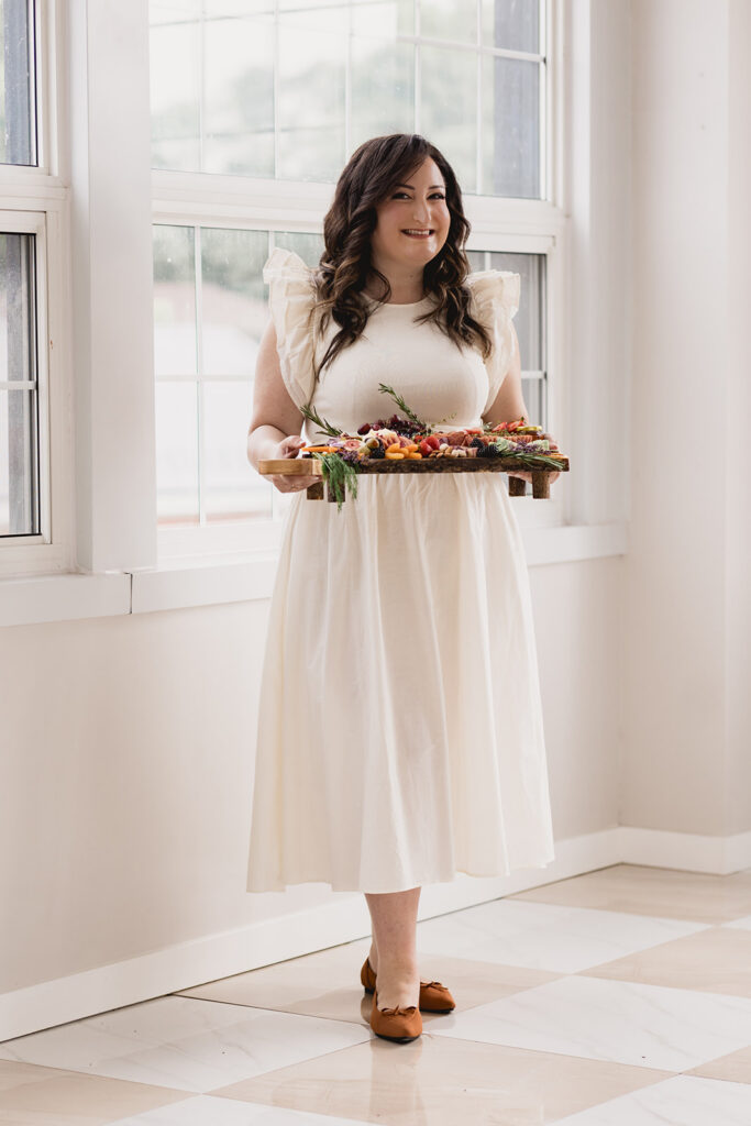 Mary Tchabrazian, owner of Marycuterie, holding a charcuterie board during a branding photoshoot by Portraits by Kendra in Waterloo Region