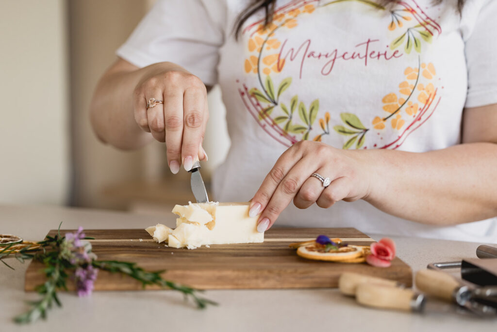 Mary Tchabrazian, owner of Marycuterie, slicing butter during a branding photoshoot by Portraits by Kendra in Waterloo Region