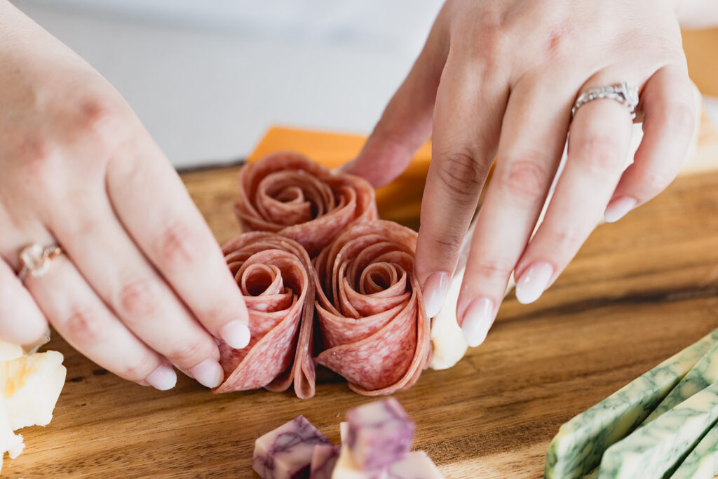Close-up photo of Mary's hands holding salami roses  during Marycuterie's branding photoshoot by Portraits by Kendra in Waterloo Region