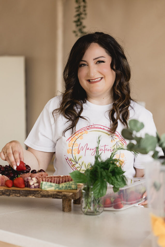 Mary Tchabrazian, owner of Marycuterie, is making a charcuterie board during a branding photoshoot by Portraits by Kendra in Waterloo Region