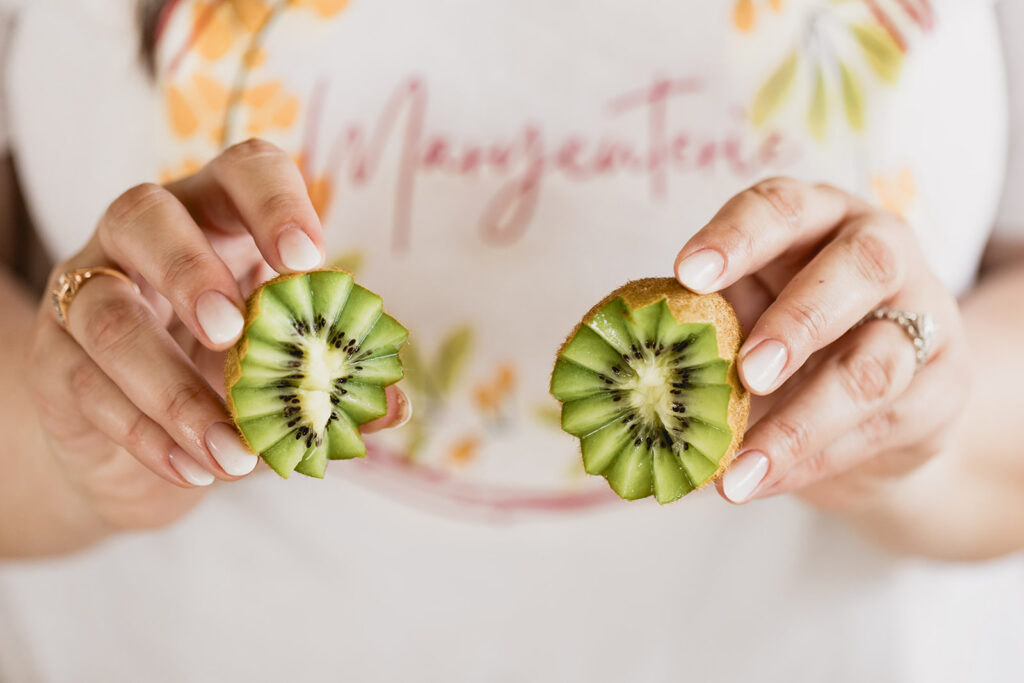 Mary Tchabrazian, owner of Marycuterie, holding a kiwi during a branding photoshoot by Portraits by Kendra in Waterloo Region