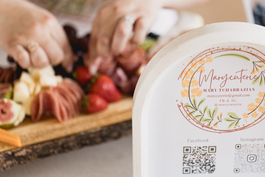 Close-up photo of Mary Tchabrazian, owner of Marycuterie, putting together a charcuterie board, taken by Portraits by Kendra during a branding photoshoot in Waterloo Region