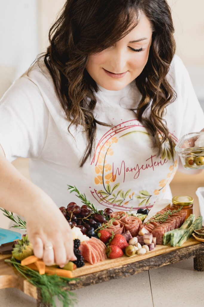 Mary Tchabrazian, owner of Marycuterie, is making a charcuterie board during a branding photoshoot by Portraits by Kendra in Waterloo Region