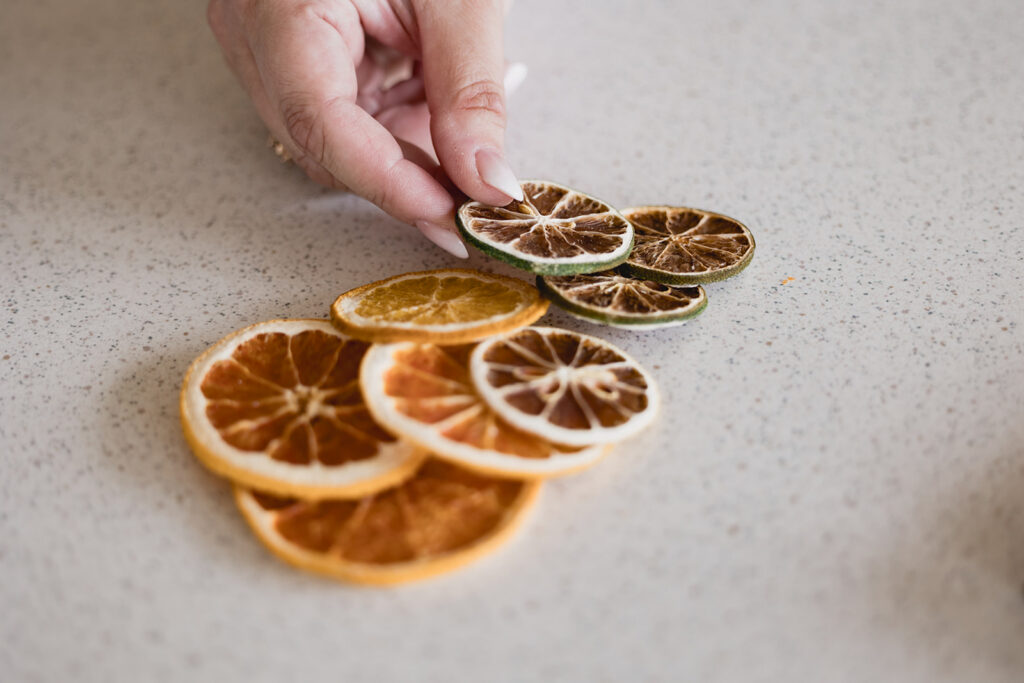 Mary Tchabrazian, owner of Marycuterie, styling slices of oranges during a branding photoshoot by Portraits by Kendra in Waterloo Region