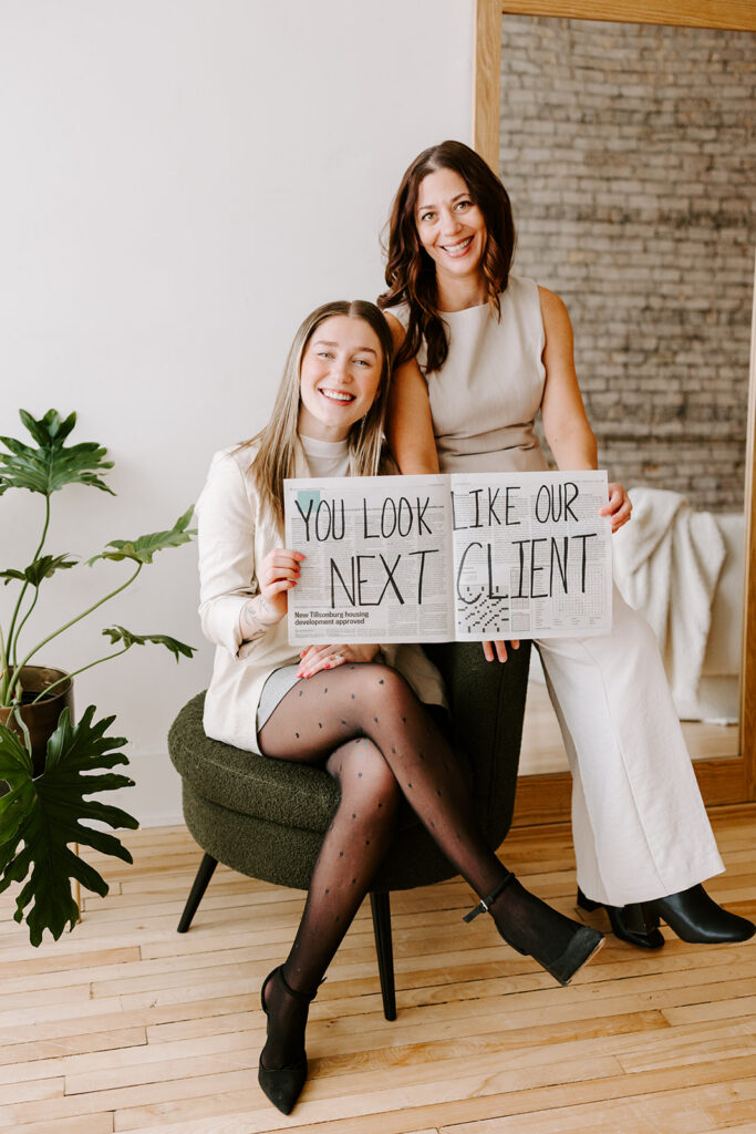Photo of the The Livingston Team holding a fun sign during a Mother-Daughter Branding Session at West Haus Studio in Downtown Kitchener, taken by Portraits by Kendra