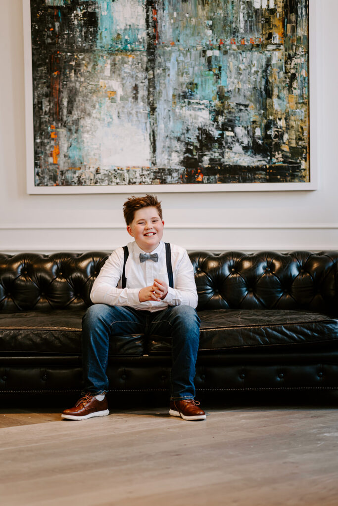 Smiling teen boy sitting on a couch.  Birthday portrait in Kitchener-Waterloo by Portraits by Kendra