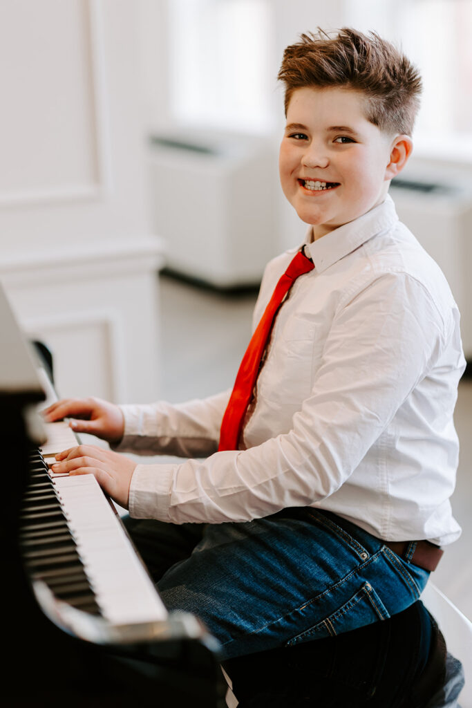 Portrait of a teen boy playing the piano.  Photo taken by Portraits by Kendra in Kitchener-Waterloo