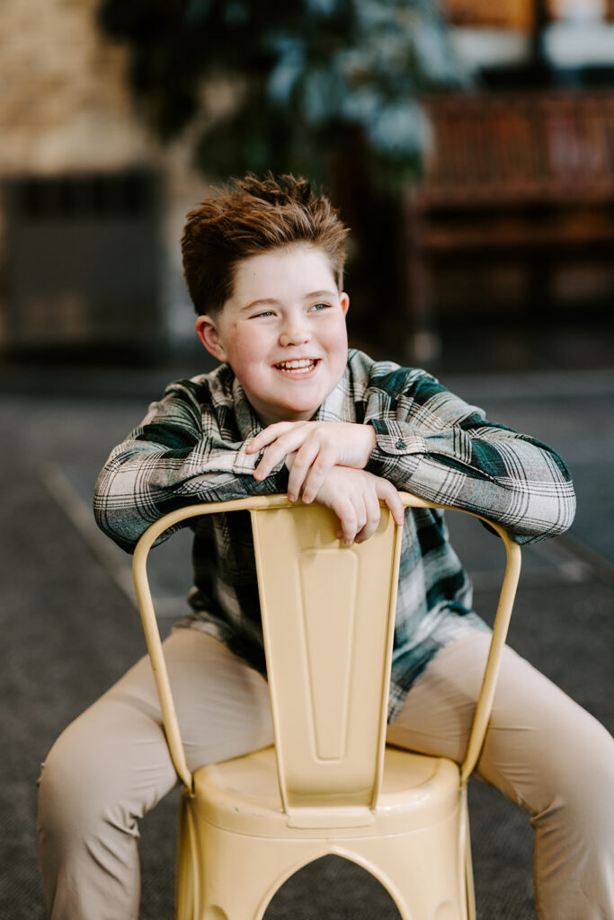 Birthday portrait of a smiling teen boy sitting on a chair—photo taken in Kitchener-Waterloo by Portraits Portrait by Kendra.