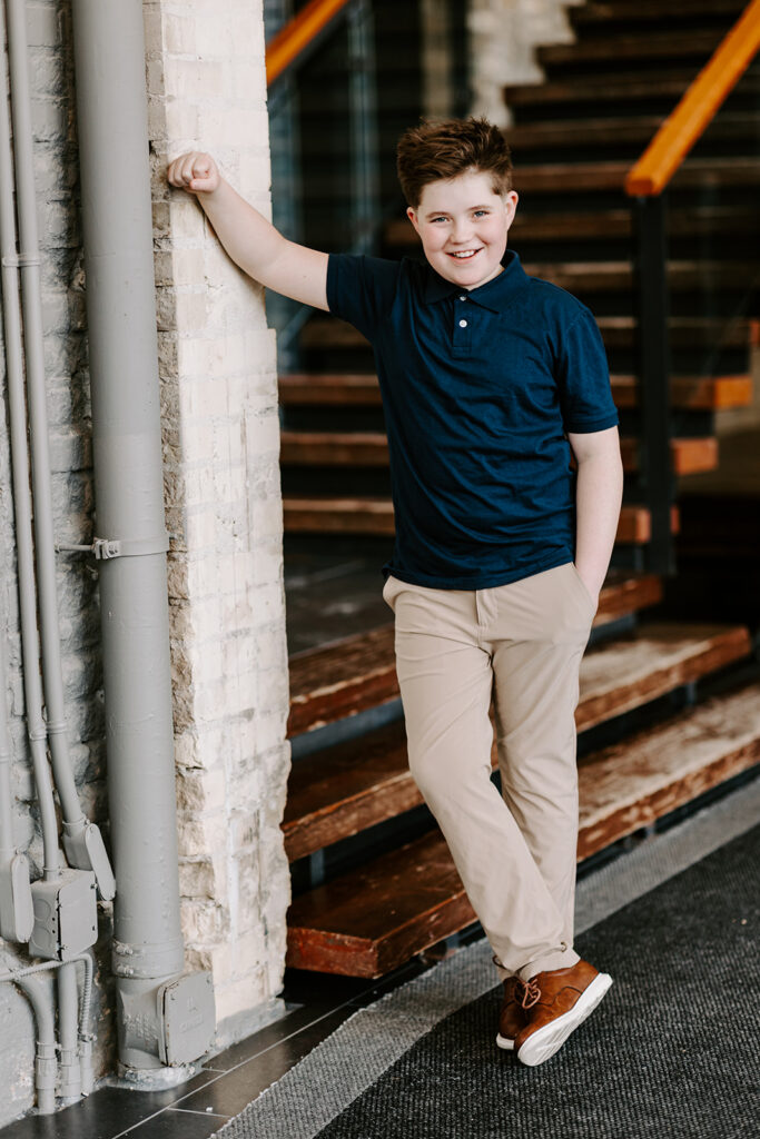 Relaxed teen boy leaning against the wall.  An indoor portrait session  in Kitchener-Waterloo by Portraits by Kendra