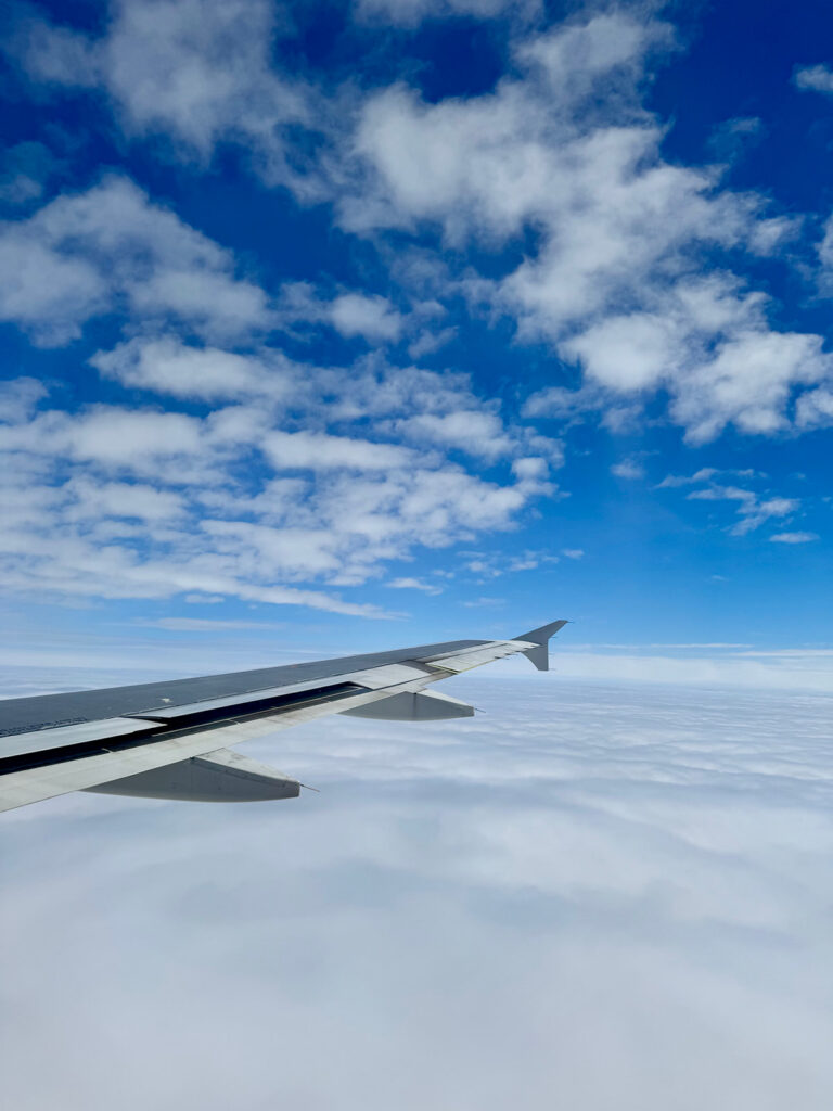 Airplane wing above clouds during flight to Miami