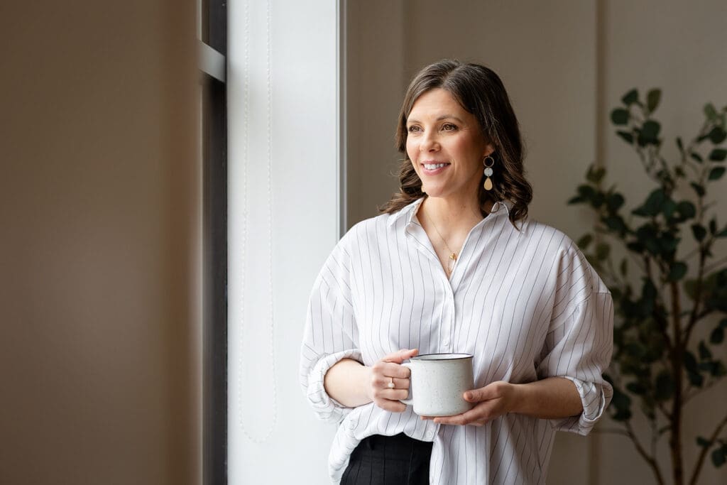 Personal branding photography session in Kitchener-Waterloo featuring a female entrepreneur holding a coffee mug in natural window light.
