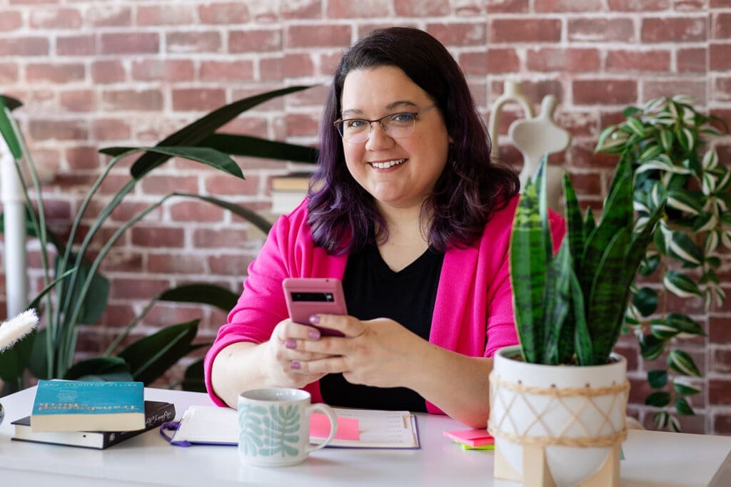 Female entrepreneur Business owner using a smartphone during a personal branding photography session in Kitchener-Waterloo.