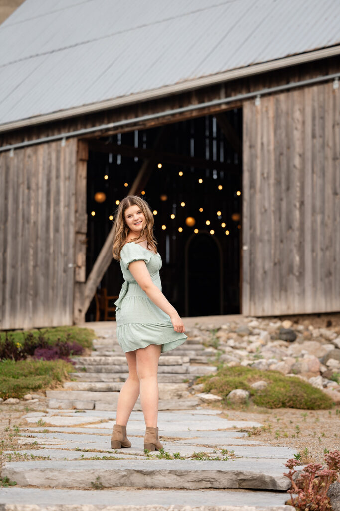 Birthday portrait of teen girl standing in front of barn doors. 