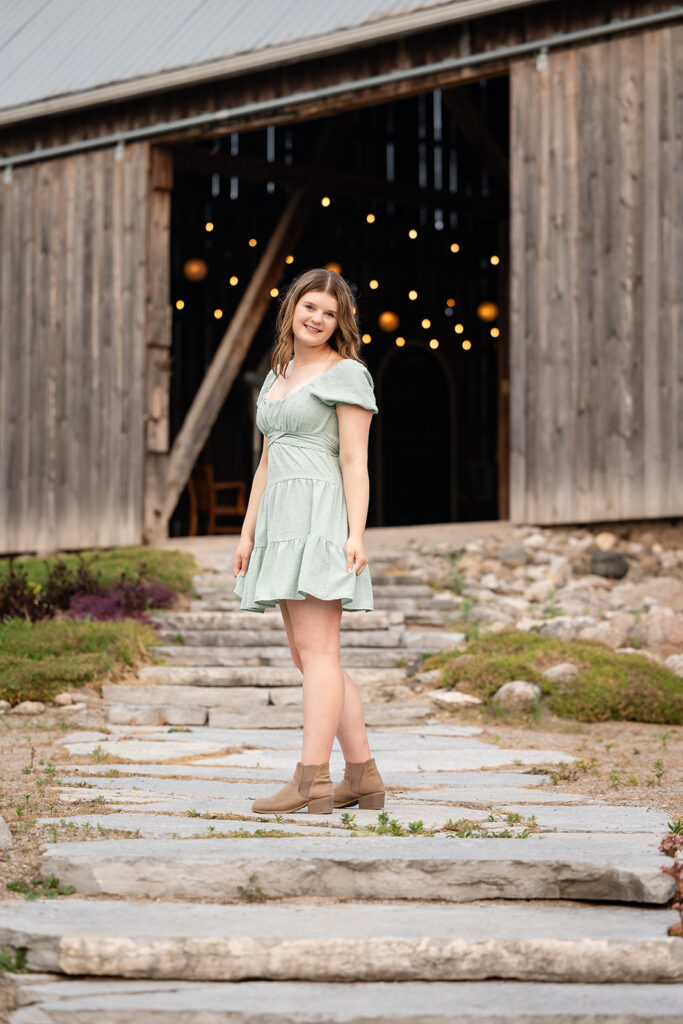 Birthday portrait of teen girl standing in front of barn doors. 