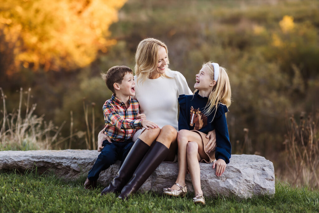 Mother laughing with her son and daughter during a candid fall family photo session in Kitchener-Waterloo.