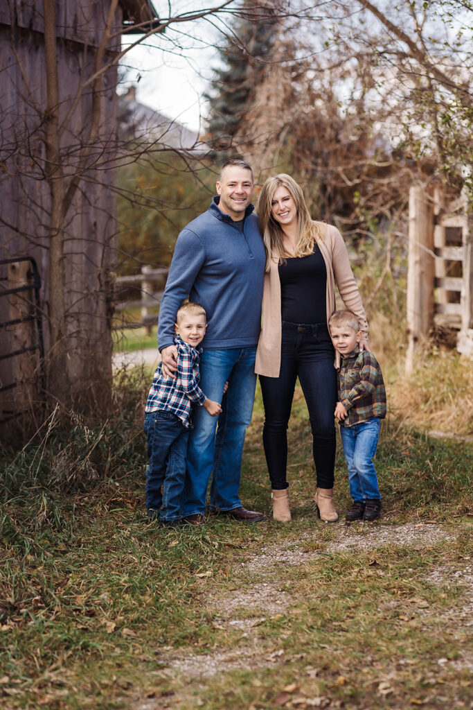 Family of four posing together outdoors during a fall family photography session in Kitchener-Waterloo.