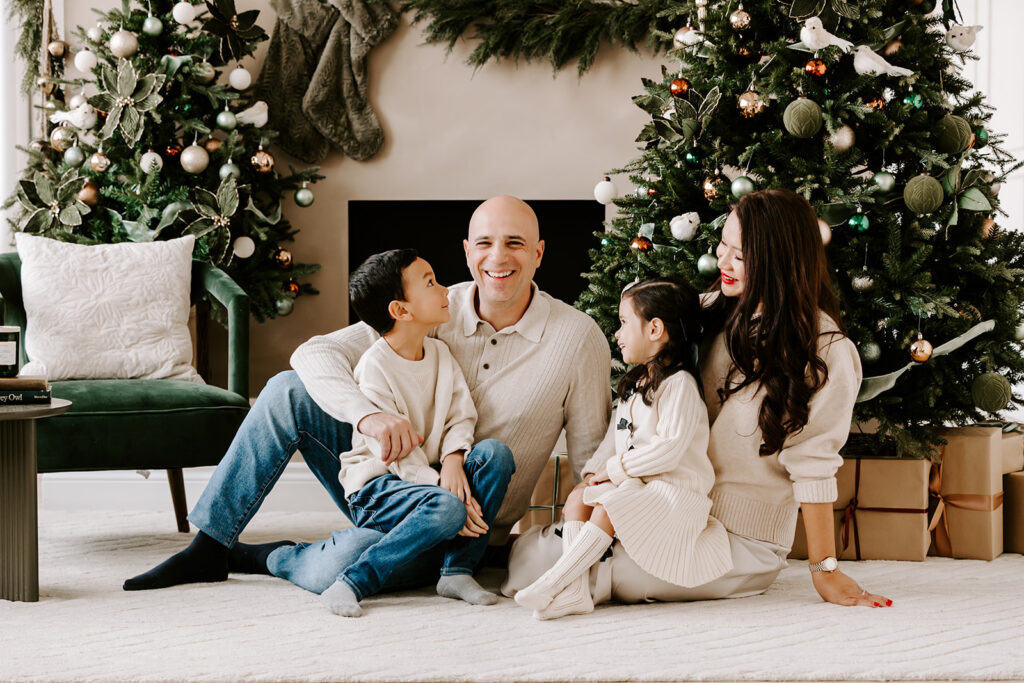 Family of four sharing a relaxed moment during a holiday studio photo session in Kitchener-Waterloo.